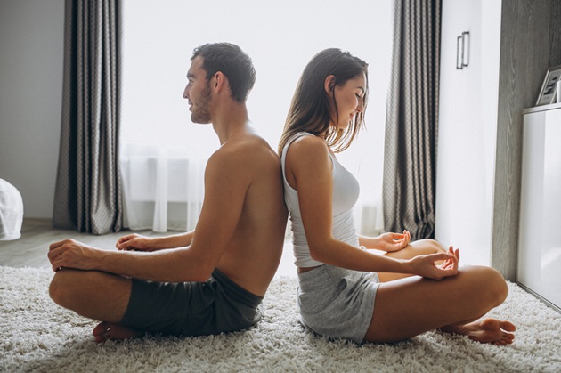 Couple at home lying on floor and exercising to boost libido